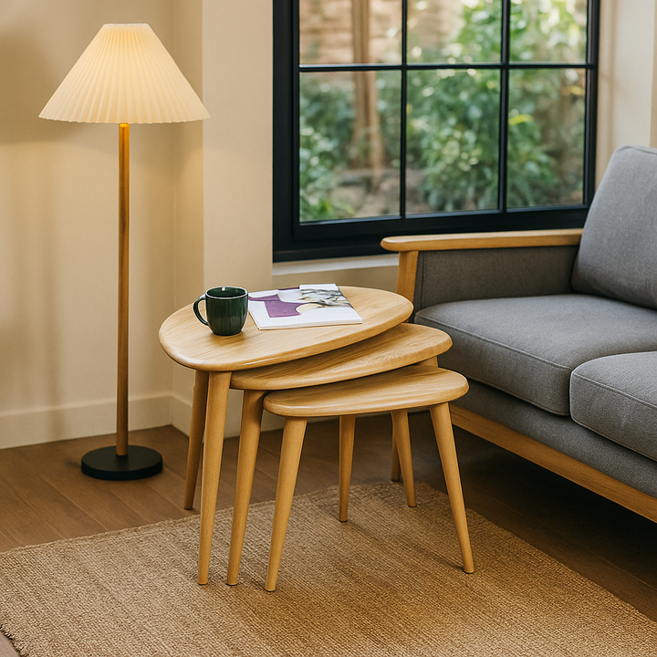 3'lu zigon sehpa takimi, masif mese agacindan yapilmis yuvarlak hatli modern tasarimi ile oturma odasinda kullanima uygun  uzerinde kitap ve yesil kupa vornom