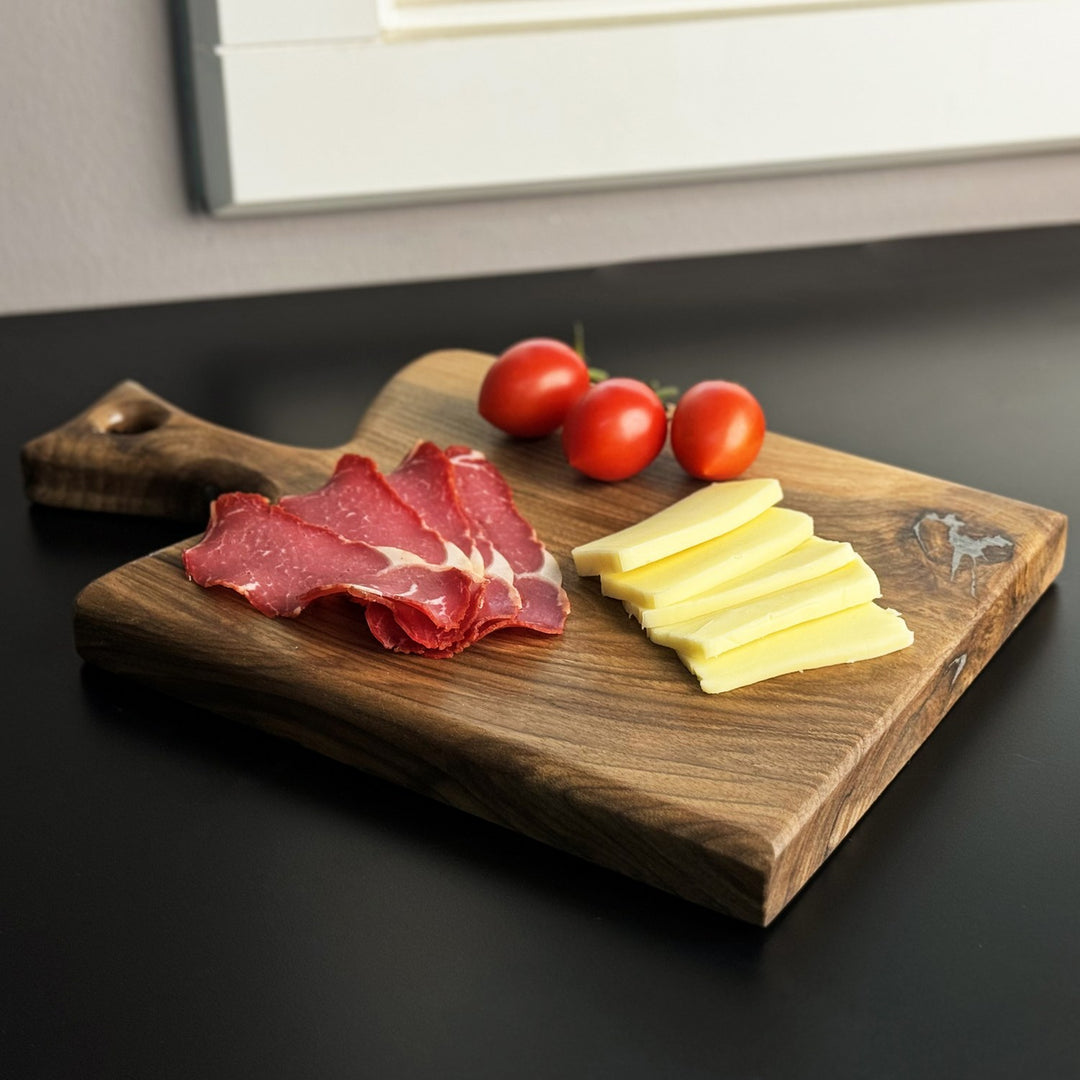 ceviz agacindan yapilmis ahsap kesme tahtasi uzerinde kasar pastirma ve domates ile sunum icin dogallik sunuyor vornom