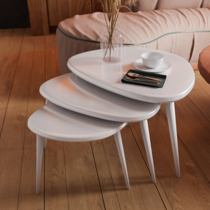 mat beyaz renkli 3'lu ahsap zigon sehpa seti uzerinde kase tabak ve catal bicak takimi bulunuyor vornom