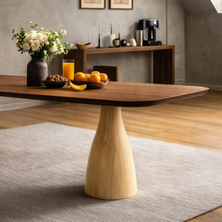 Asimetrik ayaklı, şık bir tasarıma sahip modern bir yemek masası, ahşap tabanla dikkat çekiyor.