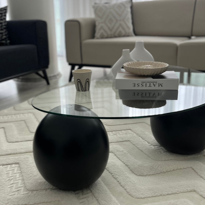 minimalist-tasarimli-cam-sehpa-siyah-yuvarlak-ayaklarla-modern-dekor