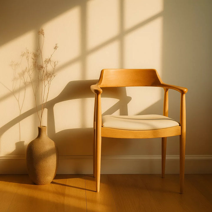 Güneşin vurduğu bir pencere önünde yer alan İskandinav stil ahşap yemek sandalyesi, Kennedy sandalyesi olarak bilinir.