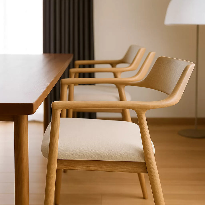 İskandinav stilinde ahşap masa ve sandalyelerin yer aldığı bir iç mekan görüntüsü.