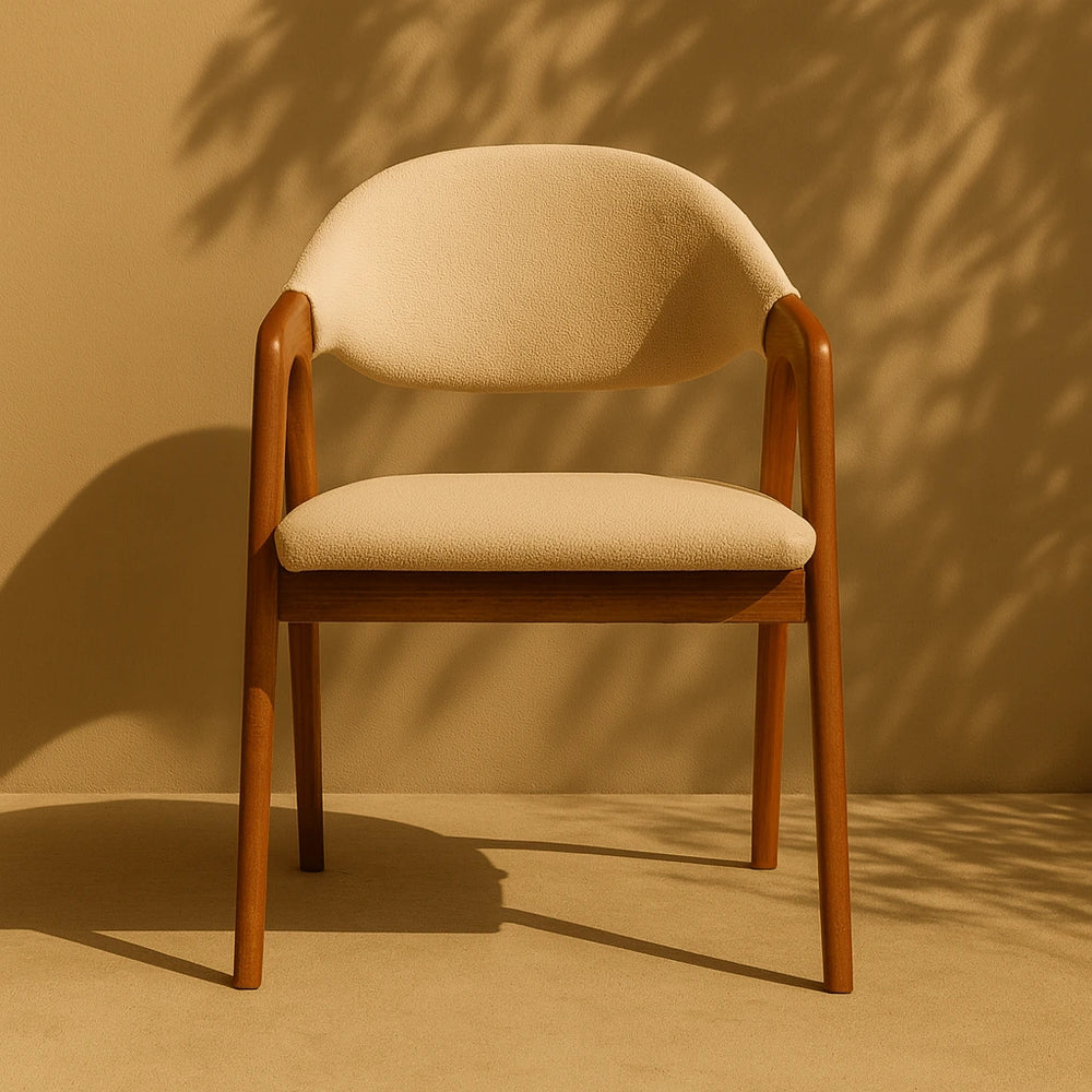 Kavisli Sırtlı Minimalist Kayın Sandalye, duvara yaslanmış tan döşemeli bir oturma alanı sunuyor.