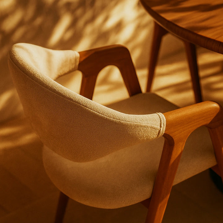 Kavisli sırtlı, bej döşemeli ve ahşap çerçeveli minimalist kayın sandalye, modern bir oturma alanı için ideal.