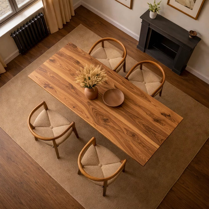 Masif Ceviz Yemek Masası, dört sandalyeyle birlikte bir masa ve vazoya sahip şık bir yemek alanı sunuyor.