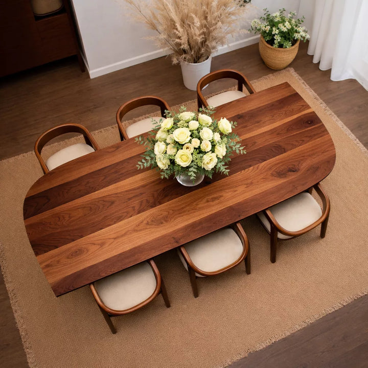 Masif Ceviz ve Kestane Yemek Masası üzerinde çiçekler bulunan ahşap masa ve sandalyeler yer alıyor.