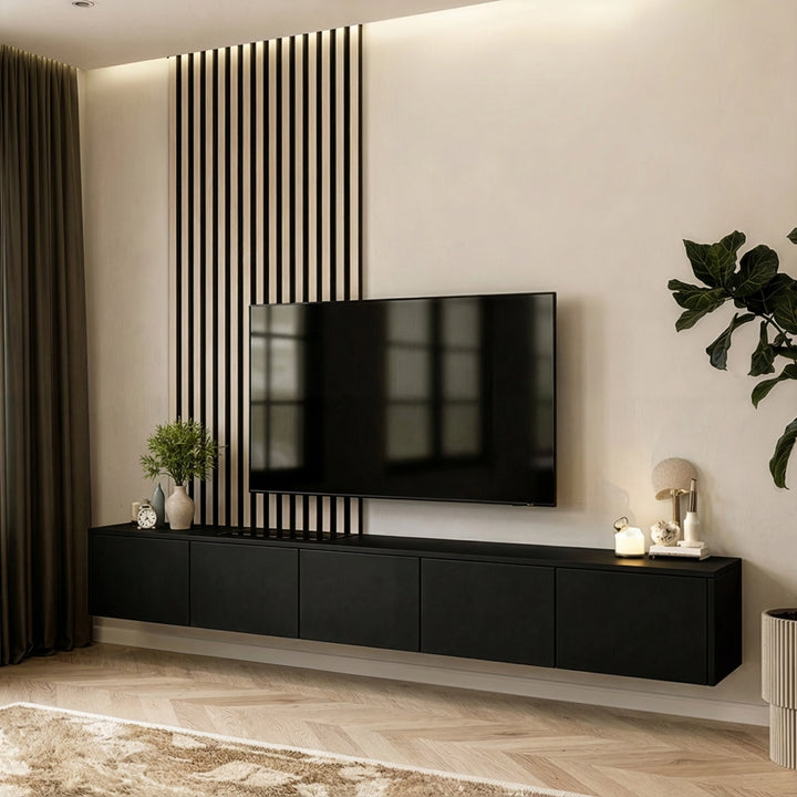 Modern bir oturma odası, siyah duvara monte TV ünitesi ile şık bir görünüm sunuyor.