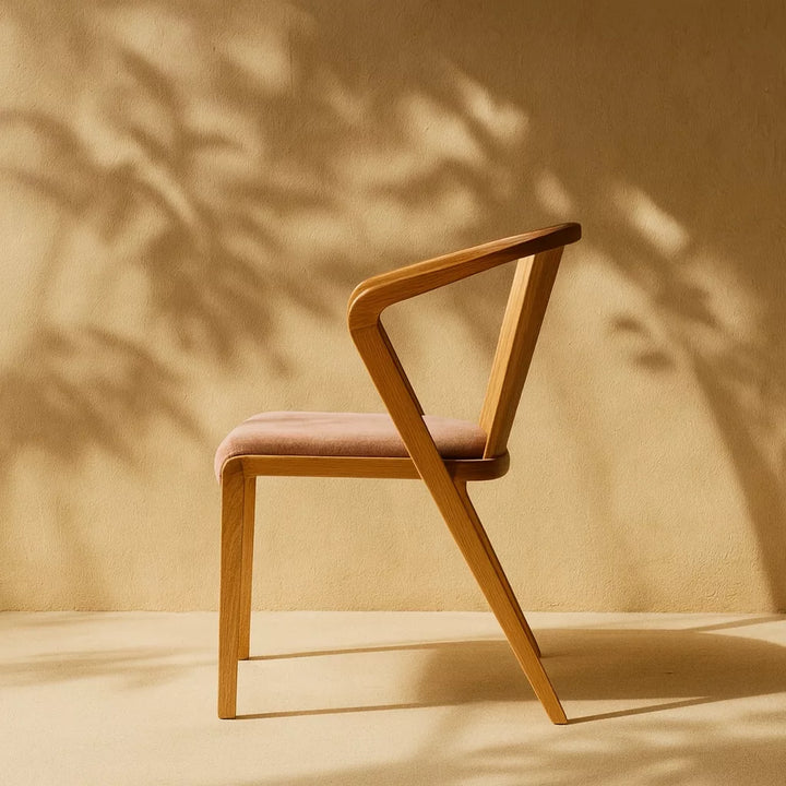Minimalist tasarıma sahip, pembe oturumlu kayın ahşap yemek sandalyesi.