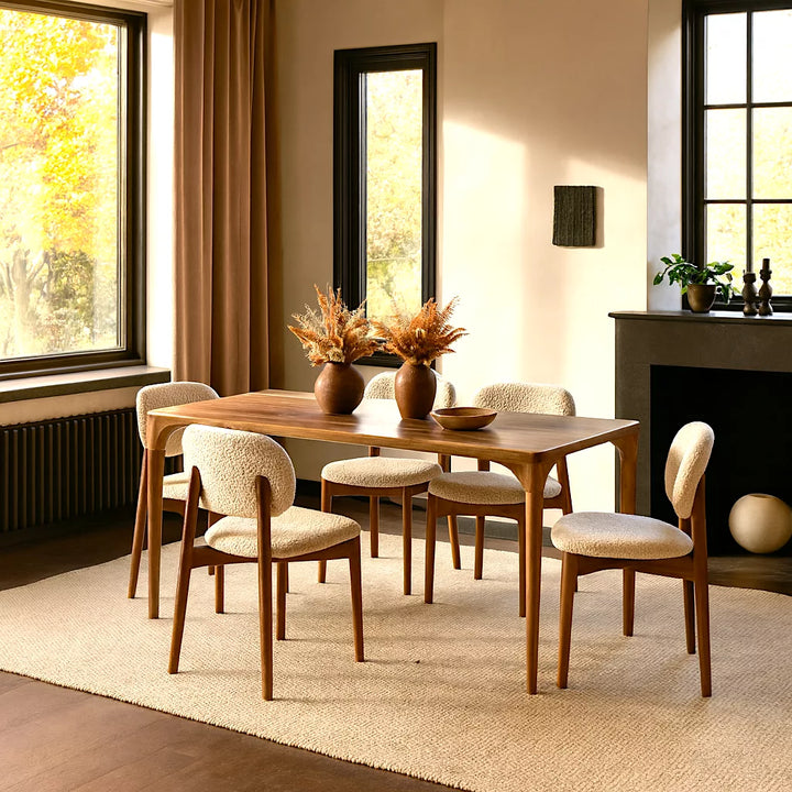 Modern İskandinav tasarıma sahip Oslo Ceviz Masif Ahşap Yemek Masası, etrafında sandalyeler ve bir vazoyla dekore edilmiştir.