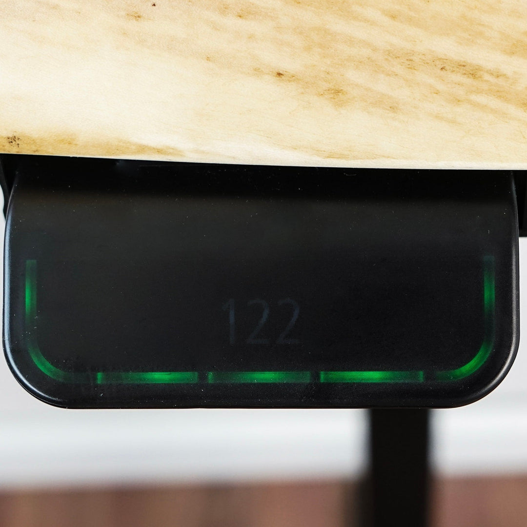 Elektrikli yukseklik ayarli masif ahsap masanin alti gorunuyor siyah metal ayaginda yesil isikli bir yukseklik gostergesi 122 cm degerini gosteriyor ve dogal ahsap dokusuyla modern bir tasarim sunuyor